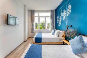 una camera da letto con due letti e una parete blu di Canary Dalat Hotel a Da Lat