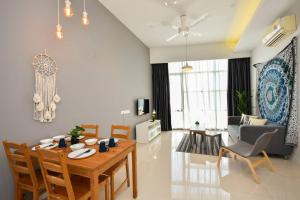 un soggiorno con tavolo e sedie in legno di D'Bohemia Suite by Nest Home 【Paradigm Mall】 a Petaling Jaya