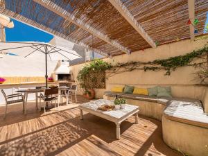 a patio with a couch and a table and an umbrella at Poetto seaside in Cagliari