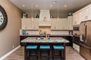 a kitchen with white cabinets and a kitchen island with blue stools at Escape On The 18th Hole in St. George