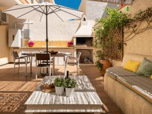 a patio with a couch and a table with an umbrella at Poetto seaside in Cagliari