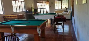 a living room with two pool tables and chairs at Pousada Pedacinho do Ceu- chalé 1 in Cunha