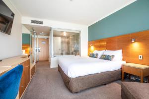 
a hotel room with two beds and a television at Gateway Hotel by Nightcap Plus in Devonport
