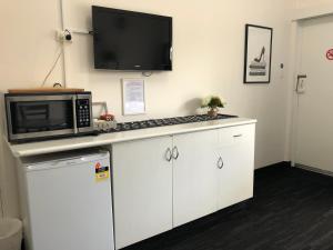 a microwave sitting on top of a kitchen counter at Blue Gums Hotel Motel in Teatree Gully