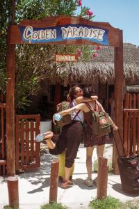 a couple kissing under a sign at a hotel at Golden Paradise Hostel in Holbox Island