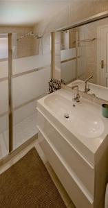 ein weißes Badezimmer mit einem Waschbecken und einem Spiegel in der Unterkunft Golden in Costa Calma