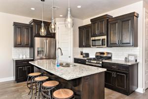 a kitchen with black cabinets and a kitchen island with stools at The View At The Escapes in St. George