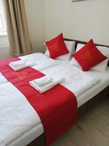 un letto con lenzuola rosse e bianche e cuscini rossi di Pension VIDHOUS 2 a Františkovy Lázně