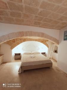 a bed in a room with a stone ceiling at B&B La Porta Vecchia in Monopoli