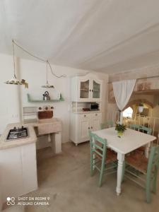 uma cozinha com uma mesa e uma mesa e cadeiras em B&B La Porta Vecchia em Monopoli