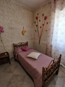 a bedroom with a bed with flowers on the wall at Casavacanze PugliaMia in Grottaglie