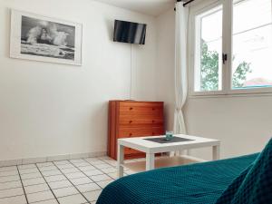 a bedroom with a bed and a table and a window at Les Pastourelles in Capbreton