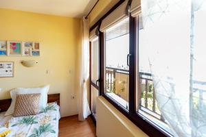 ソゾポルにあるGuest House Slavyankaのベッドルーム1室(大きな窓、ベッド1台、ベッドカバー付)