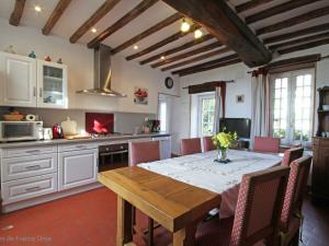 eine Küche mit einem Holztisch und Stühlen im Zimmer in der Unterkunft Gîte Sarceaux, 4 pièces, 6 personnes - FR-1-497-131 in Sarceaux