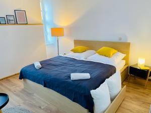a bedroom with a large bed with yellow pillows at Haus am Eck in Rechnitz