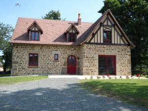 una grande casa in mattoni con una porta rossa di Gîte Juvigny-Val-d'Andaine, 5 pièces, 9 personnes - FR-1-497-115 a Saint-Denis-de-Villenette