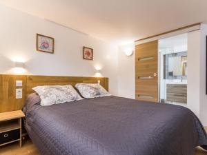 - une chambre avec un grand lit et une tête de lit en bois dans l'établissement Gîte Saint-Nazaire, 4 pièces, 6 personnes - FR-1-306-1203, à Saint-Nazaire