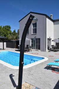 a swimming pool with a black pole in front of a house at Villa Luna in Biograd na Moru