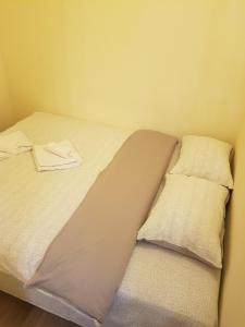 a bed with two pillows on it in a room at Apartament 1 Central in Târgu-Mureş