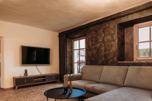 uma sala de estar com um sofá e uma televisão em Ban Hilba em Falzes