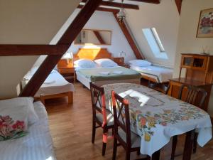 a room with two beds and two tables and chairs at Spichlerz in Rydzewo