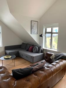 a living room with a leather couch and a table at Mengi Apartments in Reykjav&iacute;k