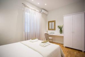 um quarto branco com 2 camas e uma secretária em The Sway Apartment- Luxury Loft in Corfu Town em Corfu Town