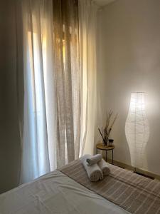a bed with two towels on it with a window at B&b Kamaraton in Marina di Camerota