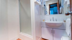 a white bathroom with a sink and a shower at Bellarine Bayside Portarlington in Portarlington