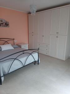 Schlafzimmer mit einem Bett, weißen Schränken und einem Kronleuchter in der Unterkunft Nel cuore di Coppito in Coppito