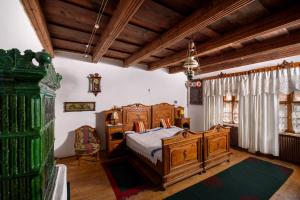a bedroom with a wooden bed and a window at Count Kálnoky's Transylvanian Guesthouses in Micloşoara
