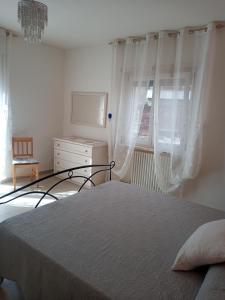 ein Schlafzimmer mit einem Bett, einer Kommode und einem Fenster in der Unterkunft Nel cuore di Coppito in Coppito