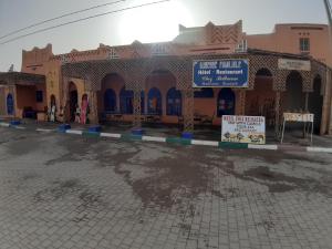 a building with a sign in front of it at Chez Belkacem in Merzouga