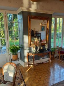 Cette chambre comprend un miroir, une table et des chaises. dans l'établissement Château De Werde, à Matzenheim