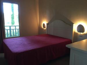 Un dormitorio con una cama roja con una ventana. en Jolie petite maison à Vieux Boucau avec piscine chauffée - Domaine du Golf de Pinsolle, en Soustons 48 fotos más