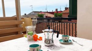 a table with a coffee pot and cups on a balcony at La Casa di Rosa in Rio Marina