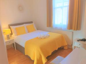 a bedroom with a bed with a yellow blanket at Julian apartment center of London in London