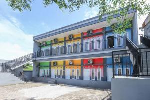 un edificio con puertas de colores vivos y una escalera en RedDoorz At Pelangi Guest House, en Balikpapan