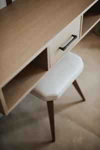 a wooden desk with a white stool underneath it at Elia Luxury Suites in Plataria