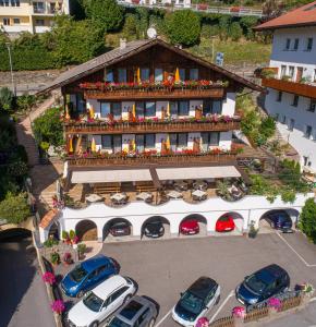 eine Luftansicht eines Gebäudes mit auf einem Parkplatz geparkt in der Unterkunft Pension Brunhild in St. Leonhard in Passeier