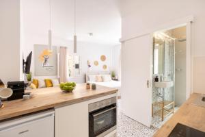 una cucina con mobili bianchi e un piano di lavoro di Little Bright Studio · Corfu Old Town a Città di Corfù