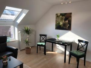 ein Wohnzimmer mit einem Tisch, Stühlen und einem Fenster in der Unterkunft Apartment in Uni- und Citynähe in Oldenburg
