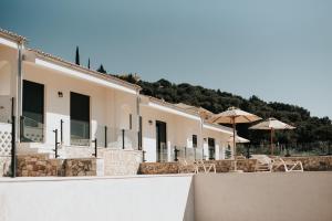 a row of buildings with umbrellas and chairs at Elia Luxury Suites in Plataria
