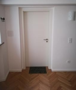 eine weiße Tür in einem Zimmer mit Holzboden in der Unterkunft Ferienwohnung im Hain in Bamberg
