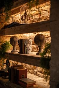 a shelf with vases and books on a stone wall at Crux in Alnwick