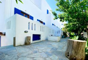 a white building with two logs in front of it at Helliniko Studios in Parikia