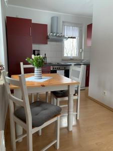 una cocina con una mesa de madera con un jarrón de flores. en Piccola Casa, en Hainewalde