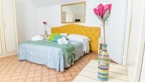 a bedroom with a bed and a vase with a flower at Albergo Diffuso Bacco Furore in Furore