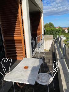 Biały stół i krzesła na balkonie w obiekcie Villa Julie w Biarritz