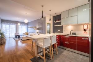 een open keuken en een woonkamer met rode kasten en witte aanrechtbladen bij Green Apartment in Funchal